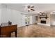 Cozy living room showcasing a brick fireplace, a ceiling fan, and access to the backyard at 1650 E Gary St, Mesa, AZ 85203