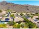 Scenic aerial view of a desert community with mountain backdrop, featuring homes with solar panels and lush landscaping at 16562 N 109Th Way, Scottsdale, AZ 85255