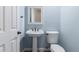 Powder room featuring pedestal sink, toilet, and framed mirror with light blue walls at 16562 N 109Th Way, Scottsdale, AZ 85255