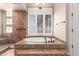 Bathroom with soaking tub, shower with glass door and tile surround, and plantation shutters at 16562 N 109Th Way, Scottsdale, AZ 85255