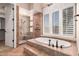 Bathroom with soaking tub, shower with glass door and tile surround, and plantation shutters at 16562 N 109Th Way, Scottsdale, AZ 85255