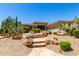 A Desert home featuring a stone walkway lined with lush landscaping and desert plants at 16562 N 109Th Way, Scottsdale, AZ 85255