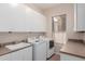 Bright laundry room with white cabinets, washer, dryer, sink, and window at 16562 N 109Th Way, Scottsdale, AZ 85255