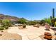A desert home with a large stone patio area showcasing beautiful desert landscaping at 16562 N 109Th Way, Scottsdale, AZ 85255
