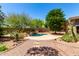 Backyard oasis with a freeform pool, waterfall feature, and lush desert landscaping providing a serene escape at 16562 N 109Th Way, Scottsdale, AZ 85255