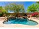 A picturesque backyard pool boasts cool, clear water and rock features that create a relaxing desert oasis at 16562 N 109Th Way, Scottsdale, AZ 85255