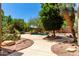 Beautiful backyard pool featuring desert landscaping, mature trees, and a rock waterfall at 16562 N 109Th Way, Scottsdale, AZ 85255
