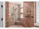 Tile shower featuring glass enclosure, built-in seat, and neutral color palette at 16562 N 109Th Way, Scottsdale, AZ 85255