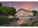 Inviting backyard with a fire pit, lush landscaping, and ample seating for outdoor enjoyment at 1761 E Countrywalk Ln, Chandler, AZ 85225