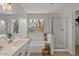 Bright bathroom with dual sinks, a garden tub, and a glass-enclosed shower at 1761 E Countrywalk Ln, Chandler, AZ 85225