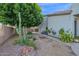 Landscaped backyard with mature trees, gravel, desert plants, and space to relax at 18161 N 63Rd Ln, Glendale, AZ 85308