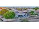 Aerial view of a backyard with a covered patio, solar panels and green trees at 18161 N 63Rd Ln, Glendale, AZ 85308