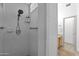 Tiled shower features modern fixtures, convenient grab bars, and built-in shelving for toiletries, enhancing accessibility at 18161 N 63Rd Ln, Glendale, AZ 85308