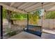 This backyard features a black wooden swing in a landscaped area with mature trees at 1820 W Seldon Way, Phoenix, AZ 85021