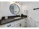 Modern bathroom with white vanity, black countertop and fixtures, round mirror, and toilet at 1820 W Seldon Way, Phoenix, AZ 85021