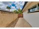 Side yard features brick wall, concrete pathway and wooden privacy gate at 1820 W Seldon Way, Phoenix, AZ 85021