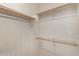 Bright, open walk-in closet features wooden rods and white shelving for optimal storage at 18250 N Cave Creek Rd # 139, Phoenix, AZ 85032