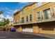Exterior of attached townhomes, showcasing individual garages and small balconies with blue sky and scattered clouds at 18250 N Cave Creek Rd # 139, Phoenix, AZ 85032