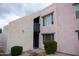 A multi-story residential building showcasing a light pink exterior, complemented by well-maintained landscaping at 1927 E Hampton Ave # 208, Mesa, AZ 85204