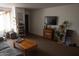 Well-lit living room with a comfortable couch, wooden table, and mounted TV at 1927 E Hampton Ave # 208, Mesa, AZ 85204