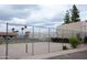 A well-maintained tennis court area enhanced by palm trees, flowering bushes, and a sturdy chain-link fence at 1927 E Hampton Ave # 208, Mesa, AZ 85204