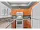 Modern kitchen with wood cabinets, counter seating, and stainless steel appliances at 2201 N Comanche Dr # 1094, Chandler, AZ 85224