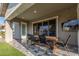 Covered patio with outdoor dining table, television, and view of backyard at 22858 E Silver Creek Ln, Queen Creek, AZ 85142