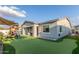 A backyard with a playhouse, patio, putting green, and artificial turf at 22858 E Silver Creek Ln, Queen Creek, AZ 85142