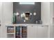 A sleek bar area with wine and beverage refrigerators, custom mirror, and stylish lighting at 22858 E Silver Creek Ln, Queen Creek, AZ 85142