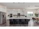 Open concept kitchen with stainless appliances, a large island with seating, modern lighting, and ample counter space at 22858 E Silver Creek Ln, Queen Creek, AZ 85142