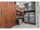 Modern laundry room featuring wood accents, stylish gray cabinetry, and state-of-the-art washer and dryer at 22858 E Silver Creek Ln, Queen Creek, AZ 85142