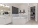 Bright main bathroom with a soaking tub, double vanity and walk-in closet at 22858 E Silver Creek Ln, Queen Creek, AZ 85142