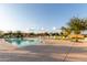 An inviting community pool with chairs, umbrellas, and lush landscaping surrounding a bright sunny day at 22858 E Silver Creek Ln, Queen Creek, AZ 85142