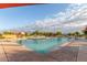 A spacious community pool with plenty of chairs, umbrellas, and other amenities on a bright sunny day at 22858 E Silver Creek Ln, Queen Creek, AZ 85142