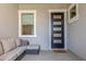 Cozy front porch featuring a modern front door, comfortable seating, and stylish decor at 22858 E Silver Creek Ln, Queen Creek, AZ 85142