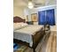 Cozy bedroom with dark wood flooring, a plush bed, and soft blue curtains at 23833 N 39Th N Ln, Glendale, AZ 85310