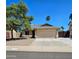 Tan single story home with desert landscaping, mature shade tree, and a two car garage at 23833 N 39Th N Ln, Glendale, AZ 85310