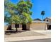 Tan single story home with desert landscaping, mature shade tree, and a two car garage at 23833 N 39Th N Ln, Glendale, AZ 85310