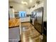 Kitchen with white cabinets, stainless steel appliances, wood floors, and butcher block island at 23833 N 39Th N Ln, Glendale, AZ 85310