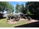 Charming backyard with a seating area, brick patio, BBQ, and mature trees, perfect for outdoor entertaining at 2413 S 121St Dr, Avondale, AZ 85323