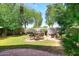 Landscaped backyard featuring green trees, a patio, and an outdoor seating area at 2413 S 121St Dr, Avondale, AZ 85323