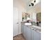 Bathroom vanity features gray cabinets and granite countertop with dual sinks and modern faucets at 2413 S 121St Dr, Avondale, AZ 85323