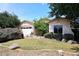 Quaint single-story home with a two-car garage, desert landscaping, and a small seating area at 2413 S 121St Dr, Avondale, AZ 85323