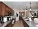 A modern kitchen featuring granite countertops, stainless steel appliances, and rich brown cabinetry at 2413 S 121St Dr, Avondale, AZ 85323