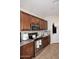 A modern kitchen featuring granite countertops, stainless steel appliances, and rich brown cabinetry at 2413 S 121St Dr, Avondale, AZ 85323