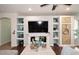 Inviting living room with custom built-ins, decorative shelving, and a cozy fireplace feature at 2413 S 121St Dr, Avondale, AZ 85323
