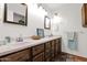Elegant bathroom featuring double sinks, framed mirrors, and dark wood cabinets at 2524 E Elmwood St, Mesa, AZ 85213