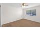 Bedroom with ceiling fan, large window for natural light and neutral carpet at 2524 E Elmwood St, Mesa, AZ 85213
