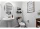 Well-lit bathroom with a pedestal sink, decorative mirror, and modern accents at 26116 N Thornhill Dr, Peoria, AZ 85383