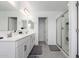 A bathroom featuring a double sink vanity, quartz counters and a glass shower with neutral walls and tile floors at 26116 N Thornhill Dr, Peoria, AZ 85383